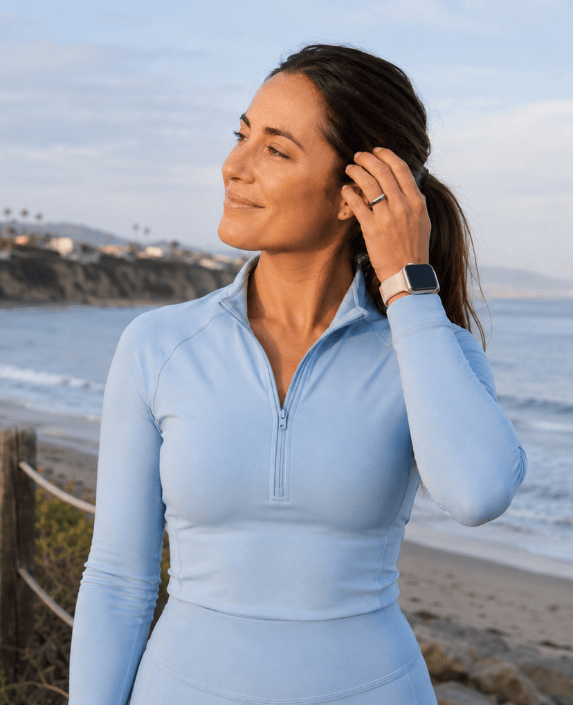 Woman checking smartwatch near the ocean